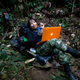 A FARC mid-level commander works on her computer at a hidden camp in the northwest Andes of Colombia.